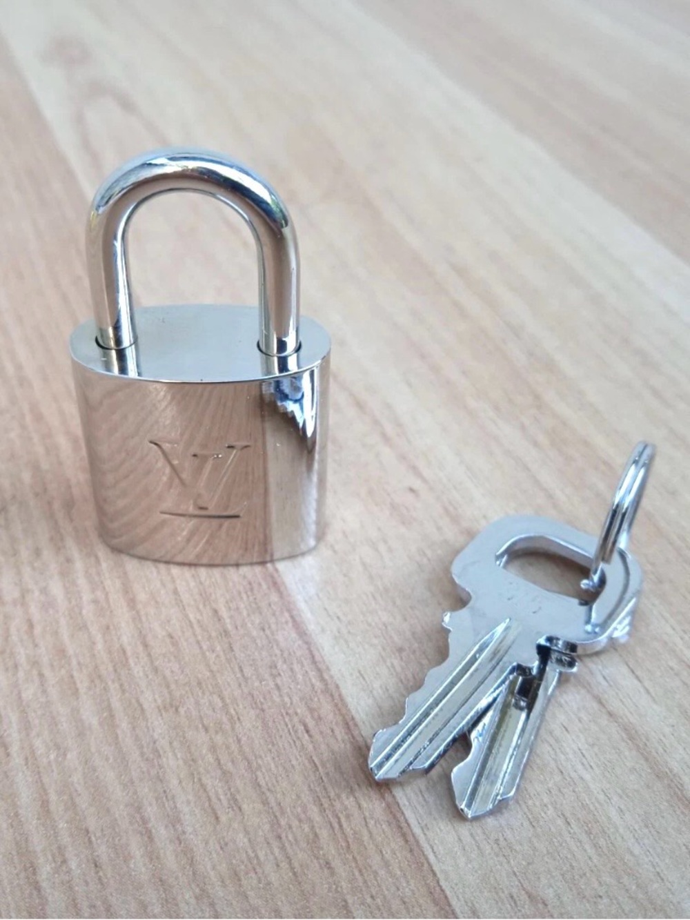 Excellent condition authentic LOUIS VUITTON Polished Silver Lock and Key Set.
